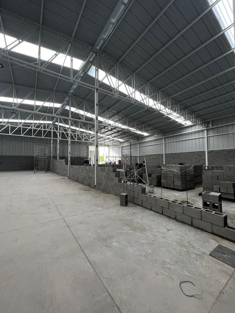 Vista interior de bodega Valtierra con iluminación lateral y columnas metálicas, constructora Fer Et Ciment León